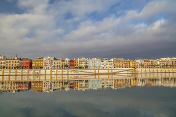 Fototapeta na wymiar Panoramic view of river and colored houses of Barrio de Triana, quarter. Sevilla, Andalucia, Spain.