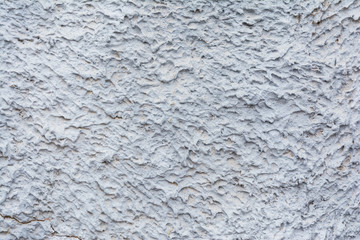 Texture of painted plaster of rough embossed wall of outer basement of building, blue abstract background