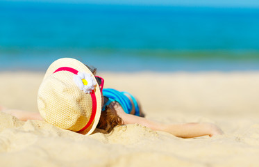 Happy child girl in bikini on beach in summer sea
