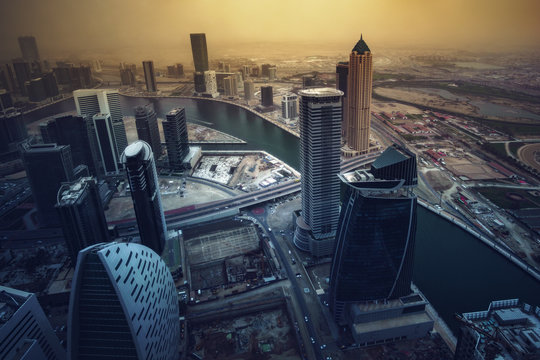 Modern architecture of a big city in dramatic light. Aerial view over the executive towers of downtown Dubai, United Arab Emirates. Stylized skyline.