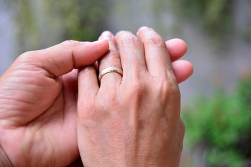 wedding rings and hands of bride and groom.