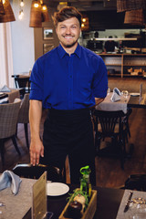 Fototapeta na wymiar Cheerful waiter in modern restaurant