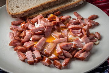 Pieces of sausage fried with egg.