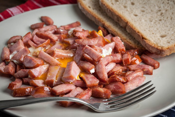 Pieces of sausage fried with egg.