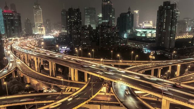 Highways in Shanghai, China, at night. Scenic aerial view of big illuminated interchange with fast moving cars. 4K Time lapse. 