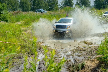 Obraz na płótnie Canvas off-road competitions, the SUV are overcome by an obstacle, a set of splashes