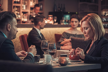 Stylish wealthy couple in a restaurant.