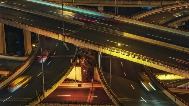 Complex overpass in Shanghai, China at night. Scenic aerial view of highways with fast moving traffic. Colorful transportation background. 4K Time lapse. 