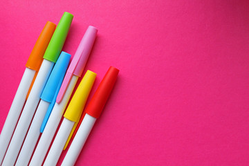 colorful pens on Pink background