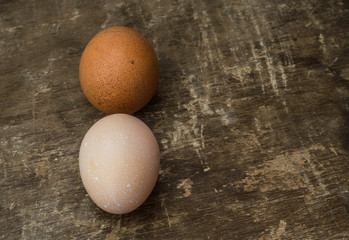 Two fresh chicken eggs on an old wooden background