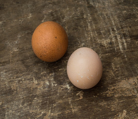 Two fresh chicken eggs on an old wooden background