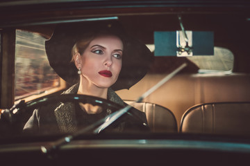 Woman behind steering wheel of a retro car