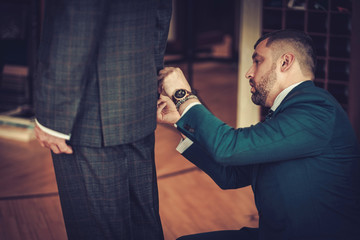 Tailor measuring client for custom made garment