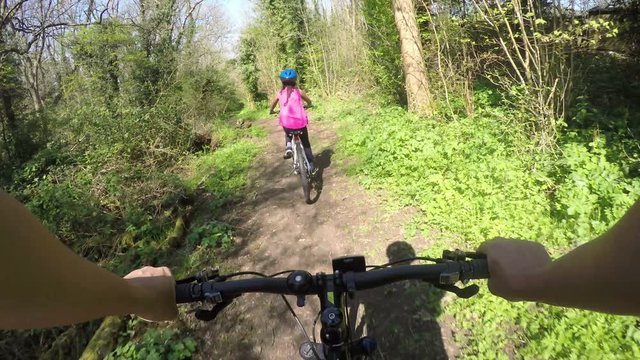 Parent and child cycling outdoors on a sunny day in the woods