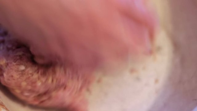Putting minced meat and vegetable mixture through mincer at home at home