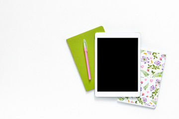 Flat lay photo of office white desk with tablet and green floral ornament notebook copy space background