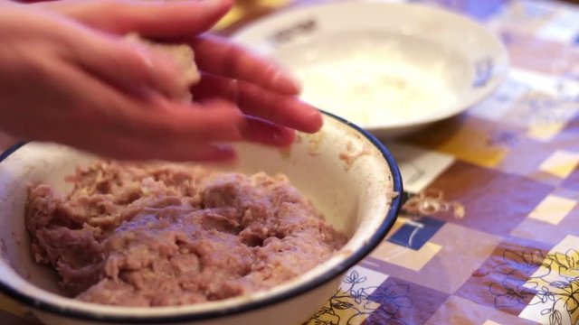 Woman making a hamburger cutlet with fresh mince in a home kitchen