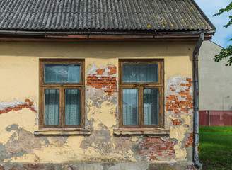 Fragment of yellow vintage old brick wall with windows and tiled roof. Textural background. Daugavpils, Latvia.