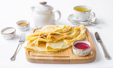 Traditional Russian pancakes with jam and honey on wooden rustic background. Maslenitsa.
