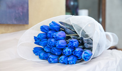 Blue tulips in paper pack on white background