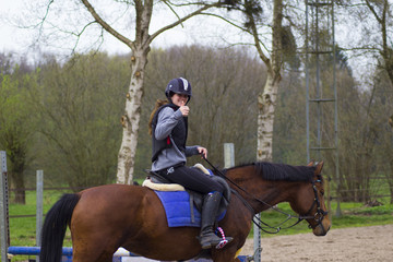 cross county horse jumping over bars by teenager girl
