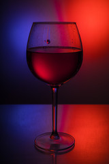 Glass Goblets on a colored background with color liquid and with reflection