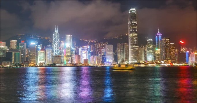 Nighttime skyline of Victoria Harbor in Hong-Kong, China. Scenic 4K time lapse with illuminated skyscrapers and water reflections.
