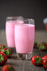 Strawberry smoothie and fresh strawberries in glass.