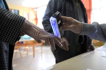 Close up of hand being checked at entrance to polling station