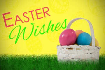 Composite image of easter eggs in wicker basket