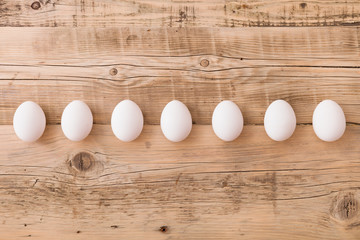 Top view on white eggs on a wooden background. Easter festive background. Flat lay.