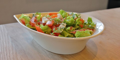 Bowl with Italian caprese salad with lettuce, mozzarella  and tomato