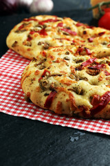 Hot pizza slice with melting cheese on a rustic wooden table.