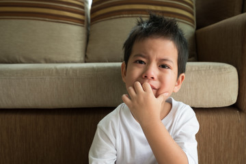 Asian boy crying  in the living room.
