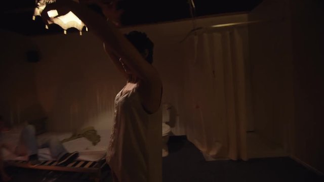  Drug addict couple in gloomy apartment. Woman dancing in euphoric state