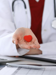 Unknown female doctor with stethoscope holding heart. Children's cardiology and medical care, stop...