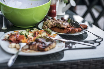 Assorted delicious grilled meat with salad in background white plate on table for family bbq party