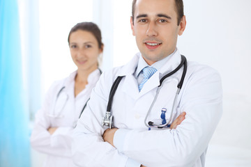 Fototapeta premium Cheerful smiling male doctor with medical staff at the hospital