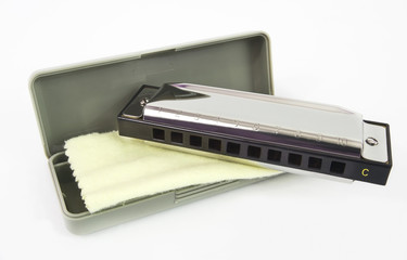 Harmonica with case and cleaning cloth. Isolated.