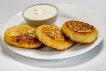 A dish of fried syrup with sour cream on a white plate