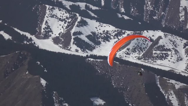 Flight of a tourist on a paraglider against the backdrop of beautiful mountains