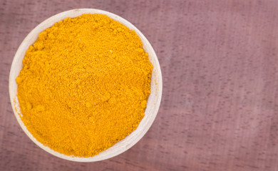 Turmeric powder in the wooden bowl (Curcuma longa)