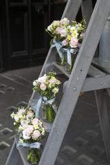 bouquet of lisianthus, roses and carnations on the steps of the staircase as decoration of the entrance to the house