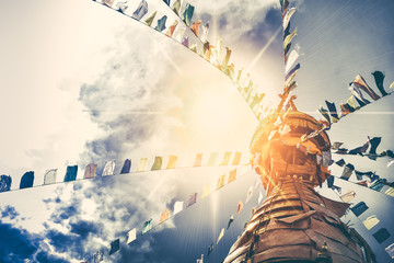 Nepal Religion Culture. Stupa in Swayambhunath Monkey temple with colorful prayer flags in Kathmandu. Cloudy blue sky with sun in the background