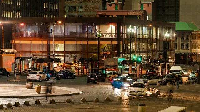 Static timelapse at night of a busstation and parking area in Ghandi Square in the city centre of Johannesburg, South Africa during peak traffic time