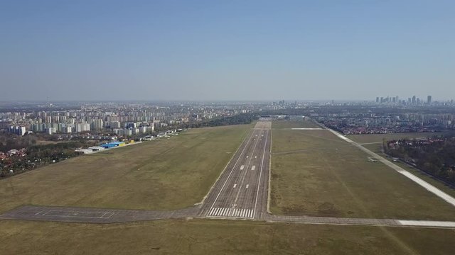 Propeller airplane taking off from airport runway on a sunny day, aerial shot. 4K video