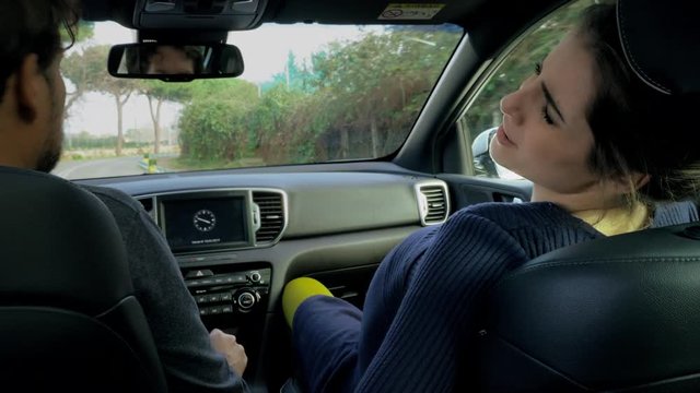 Man driving car while pregnant woman has strong contractions ready to deliver baby