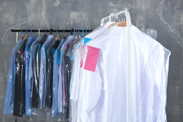 Rack of clean clothes hanging on hangers at dry-cleaning