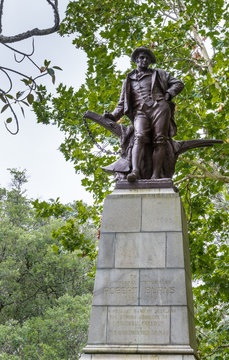 Auckland, New Zealand - March 1, 2017: Full Large Bronze Robert Burns Statue In The Domain Park. Green Tree Background With Gray Sky.