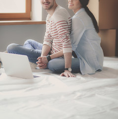 Young couple sitting on the floor of their new apartment